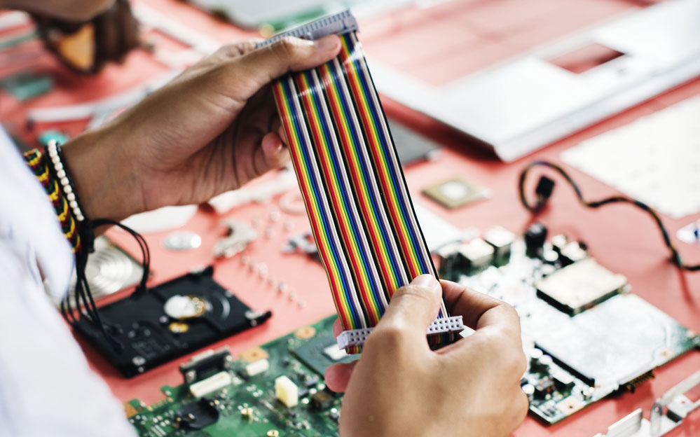 Caption: A closeup of a person holding a flat cable