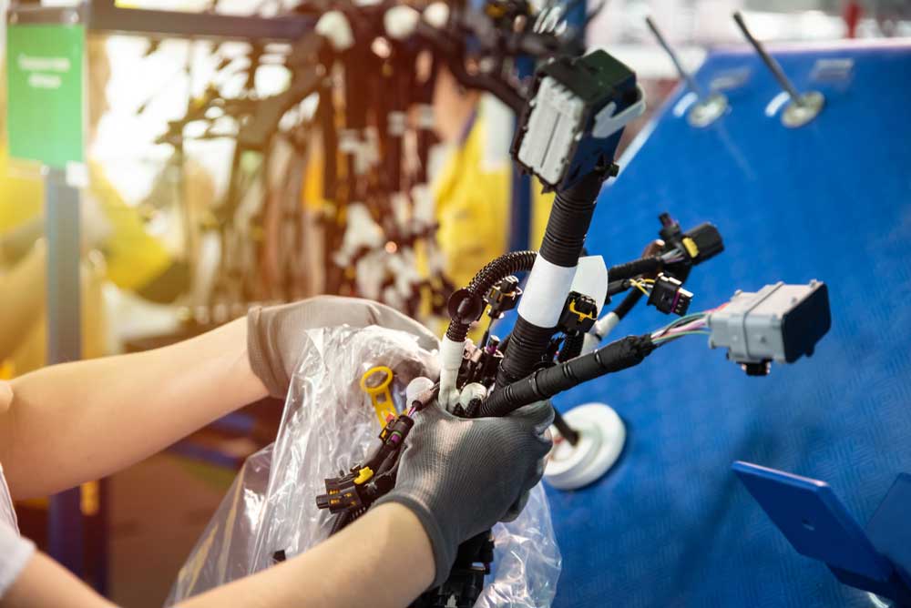 Worker packing wire harness in the production line